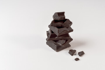 Dark bitter sweet chocolate pieces on white isolated background