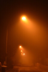 Straße mit Laternen bei Nacht im Nebel