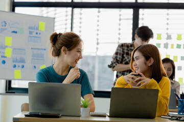 A startup company run by a new generation, two female employees are working together to plan and solve problems within the company, they are young, talented and forward-thinking employees.