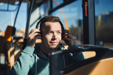 Man listening music in wireless headphones while commuting by public transportation. .
