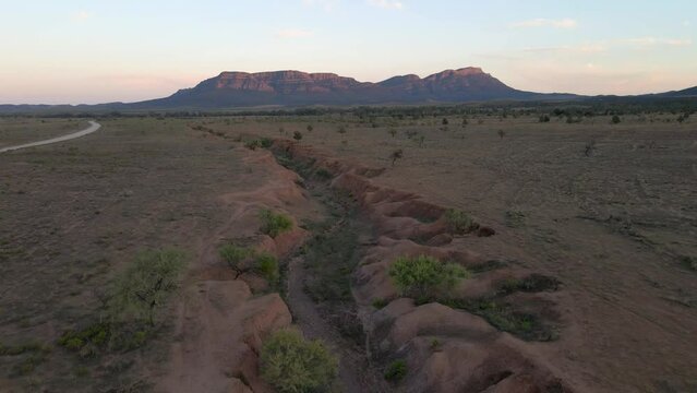 Wilpena Pound in distance, Aerial pullback revealing idyllic Outback Landscape. Australia