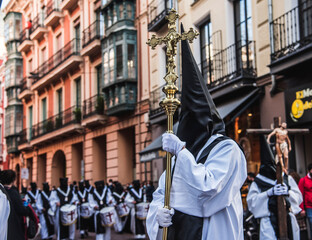 Miembro de la cofradía de Nuestro Padre Jesús Resucitado de Valladolid, España, portando una cruz dorada durante una procesión de Semana Santa. 