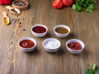 assorted sauces on wooden table, ketchup, adjika, tomato sause, garlic sause