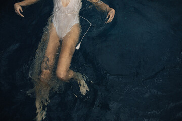 Overhead view of feminine woman swimming in sparkle dress