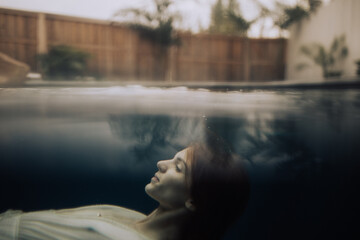 A beautiful young woman surfacing still water