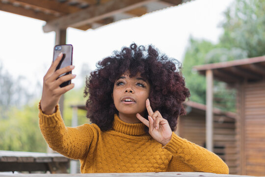 Young afro woman taking a selfie to share on her social networks.