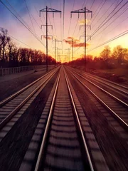 Fotobehang Reizen op treinrails naar het zonlicht aan de verre horizon © deberarr