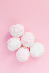 White soft marshmallows on a pink background. Delicate dessert view from above. Stylish and creative design for confectionery and cafe