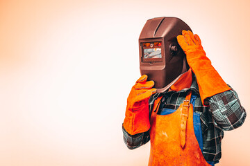 Heavy industry worker in a protective suit with a mask to protect the eyes and face, fiery colors, Space for text - obrazy, fototapety, plakaty