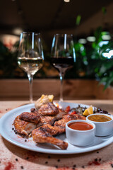 Georgian cuisine dish roasted chicken tapaka on plate and wine in restaurant