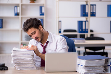 Young male employee and too much work in the office