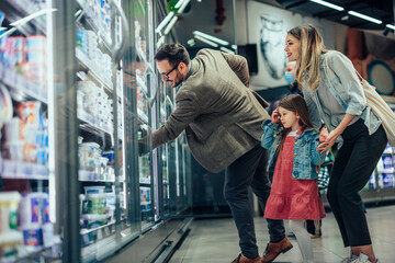 Parents and daughter shopping together in grocery store
