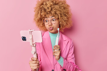Surprised female blogger explains how to use innovative electric toothbrush keeps lips rounded...