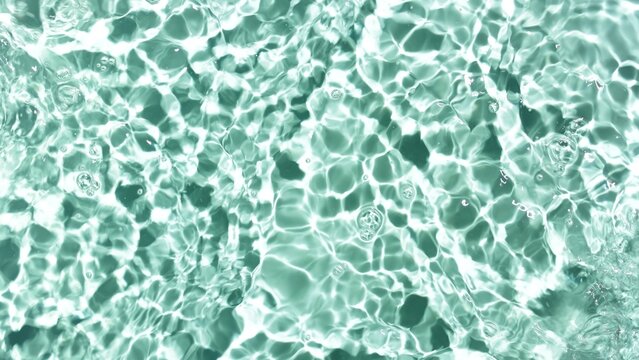 Water ripples and waves on mint green background | Cosmetic background, sunscreen commercial concept