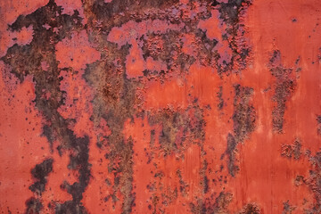Old red painted metal surface with extensive corrosion spots background.