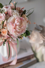 Bouquet with roses, hydrangea. Stabilized flowers in a white ceramic vase at home on the dressing table. Interior decor.