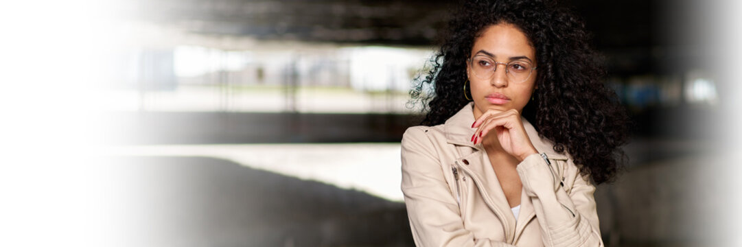 Beautiful latin girl wearing casual clothes serious face thinking about question with hand on chin, thoughtful about confusing idea