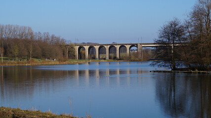 Obraz premium railway bridge over the lake on a spring evening in a city in Germany