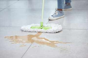 I cant believe i spilled coffee again. Shot of a woman mopping her floor.
