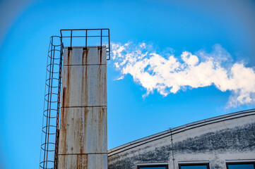 Factory chimney against the blue sky