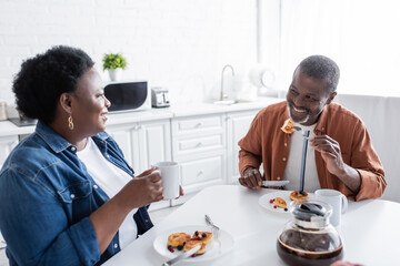 cheerful and senior african american couple having breakfast.