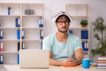 Young male student preparing for exams in the classroom