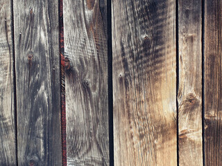 Texture of old wood. Fragment of an old fence. An aged photophone in black and brown, with golden and warm hues.