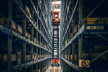 Modern distribution warehouse interior with many goods in boxes on shelves.