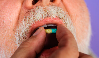 Fototapeta premium Medication treatment. Man taking capsule in mouth. Pharmaceutical pills, Vitamins, virus protection.