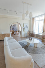 fashionable modern design luxury apartment in light colors. bright day behind huge windows. stylish decoration and no one inside.