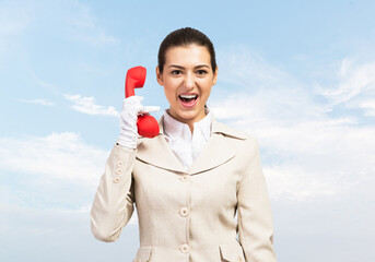 Expressive woman holds handset phone on distance