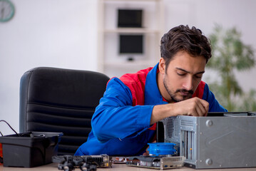 Young male repairman repairing computer