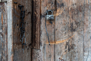 Old lock and chain on an old door. Padlock on the barn. Old doors.
