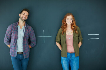 Well never know unless we try. Shot of a young couple standing in front of a blackboard with symbols written on it.