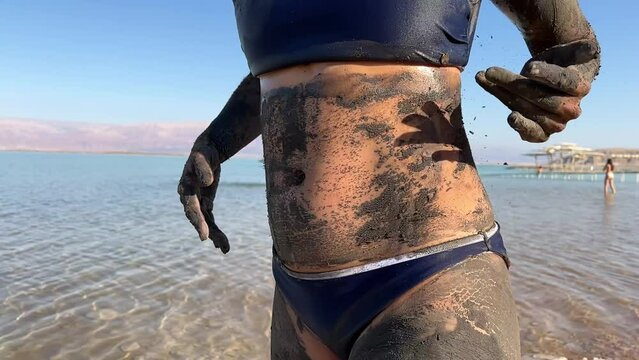 Asian woman using mud in the Dead Sea