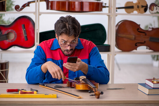 Young man repairing musical instruments at workshop