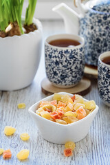 Tea time. A tea set with small blue patterns, candied fruits. Close up. Photo