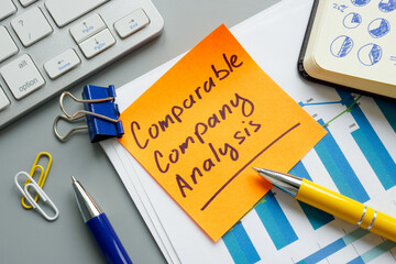 A comparable company analysis CCA report and notepad. - obrazy, fototapety, plakaty