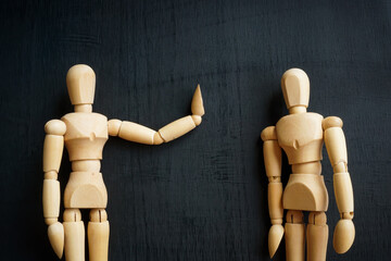 Assertiveness and confidence concept. Two wooden figurines on the dark surface. - obrazy, fototapety, plakaty