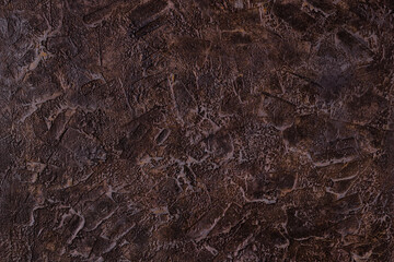 Fototapeta na wymiar Abstract brown plastered textured grunge background in the form of a rough covered stucco wall, closeup