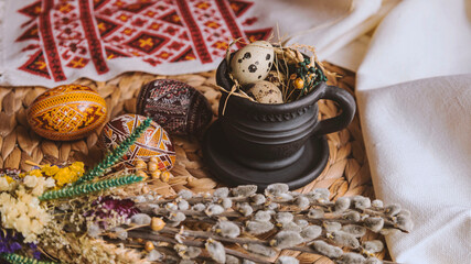 Palm Sunday in the Ukrainian style. Easter eggs, quail eggs, embroidered towel. Black cup in vintage style. Easter in Ukraine.