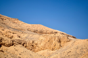 Fototapeta na wymiar Desert landscape in Egypt. View of sandy hill against clear blue sky. Copy space for text. Selective focus.