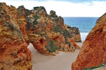 Close Up of Small Cave in Rocky Cliff on Sandy Beach  
