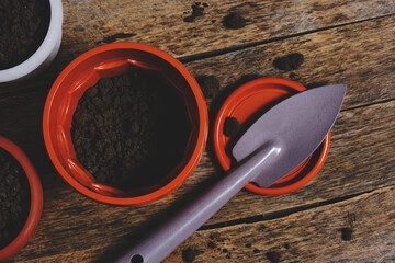 Flower pots and decorative gardening spatula on a wooden background.