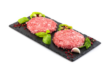 Uncooked minced meat patties on black board