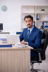 Fototapeta premium Young male employee working in the office