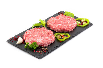 Uncooked minced meat patties on black board