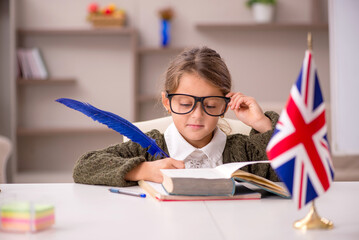 Young little girl studying english language at home