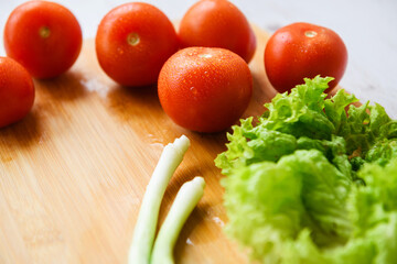 Fresh vegetables lie on a wooden cutting board