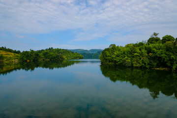 Fototapeta na wymiar Calm view of dam water surrounded with green trees in Kuala Kubu Bharu, Selangor, Malaysia.
